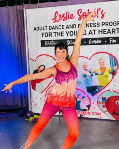Leslie Sokol standing in front of her Young at Heart banner